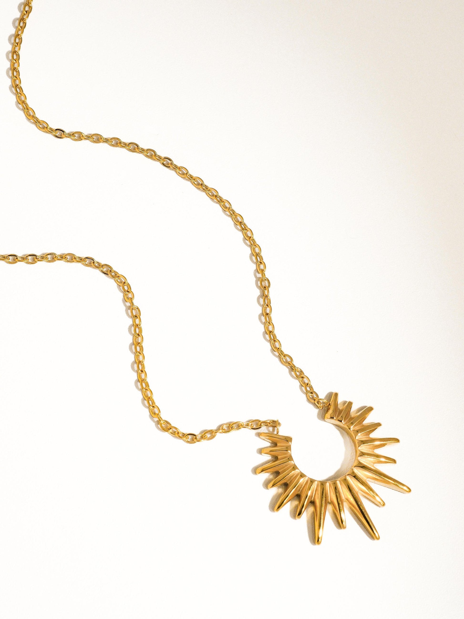 Sun pendant necklace on a white background. 