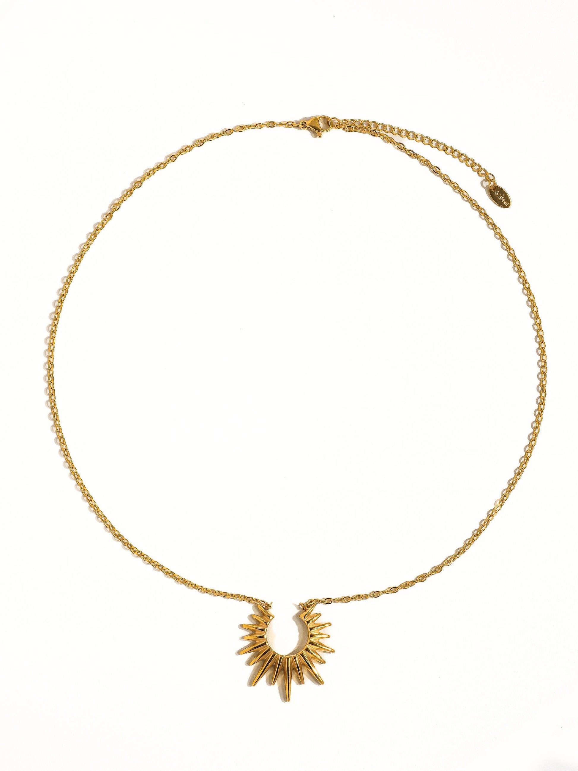 Small chain necklace with a sun pendant on a white background.