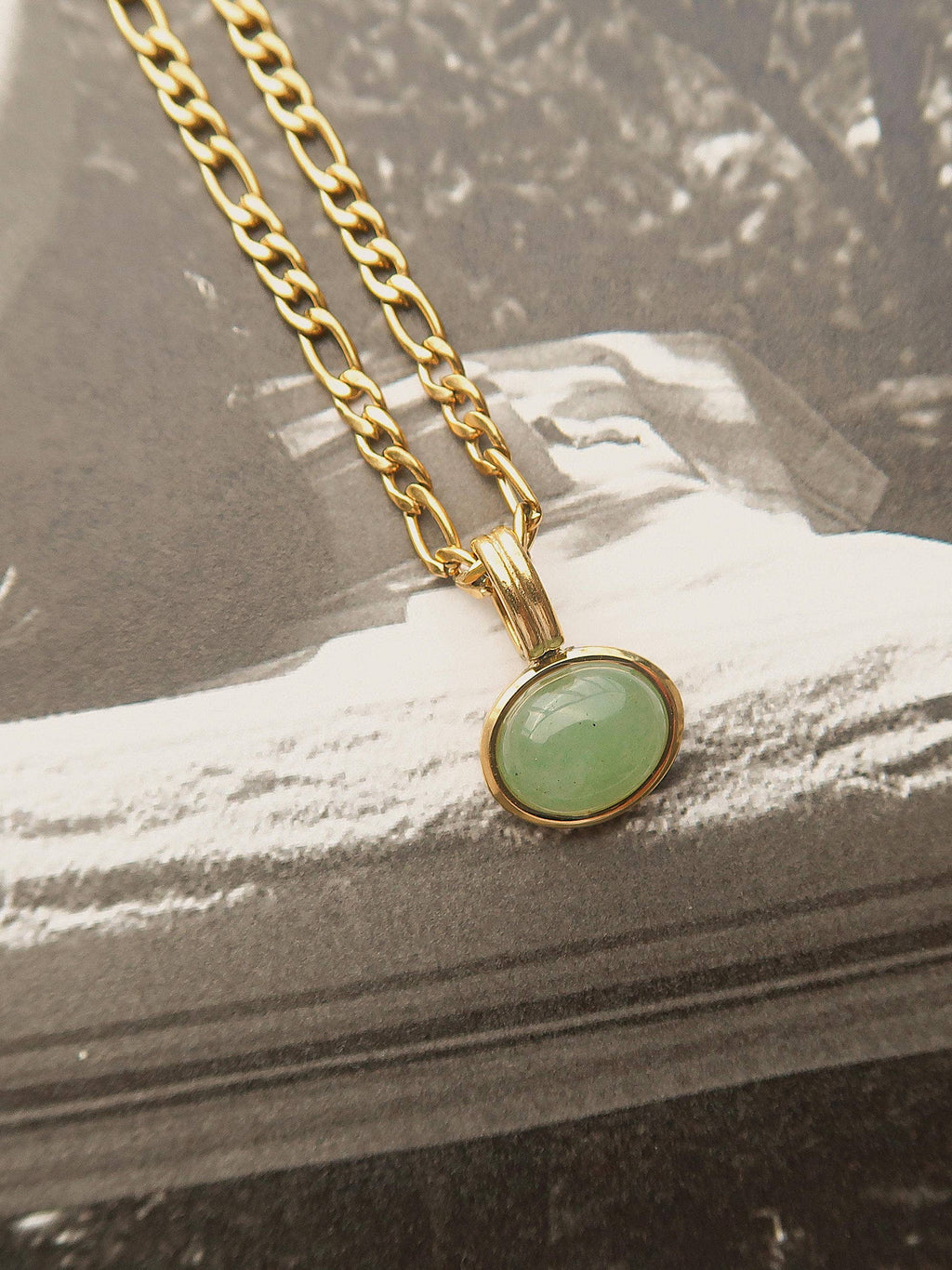 Necklace with a green pendant on a textured surface