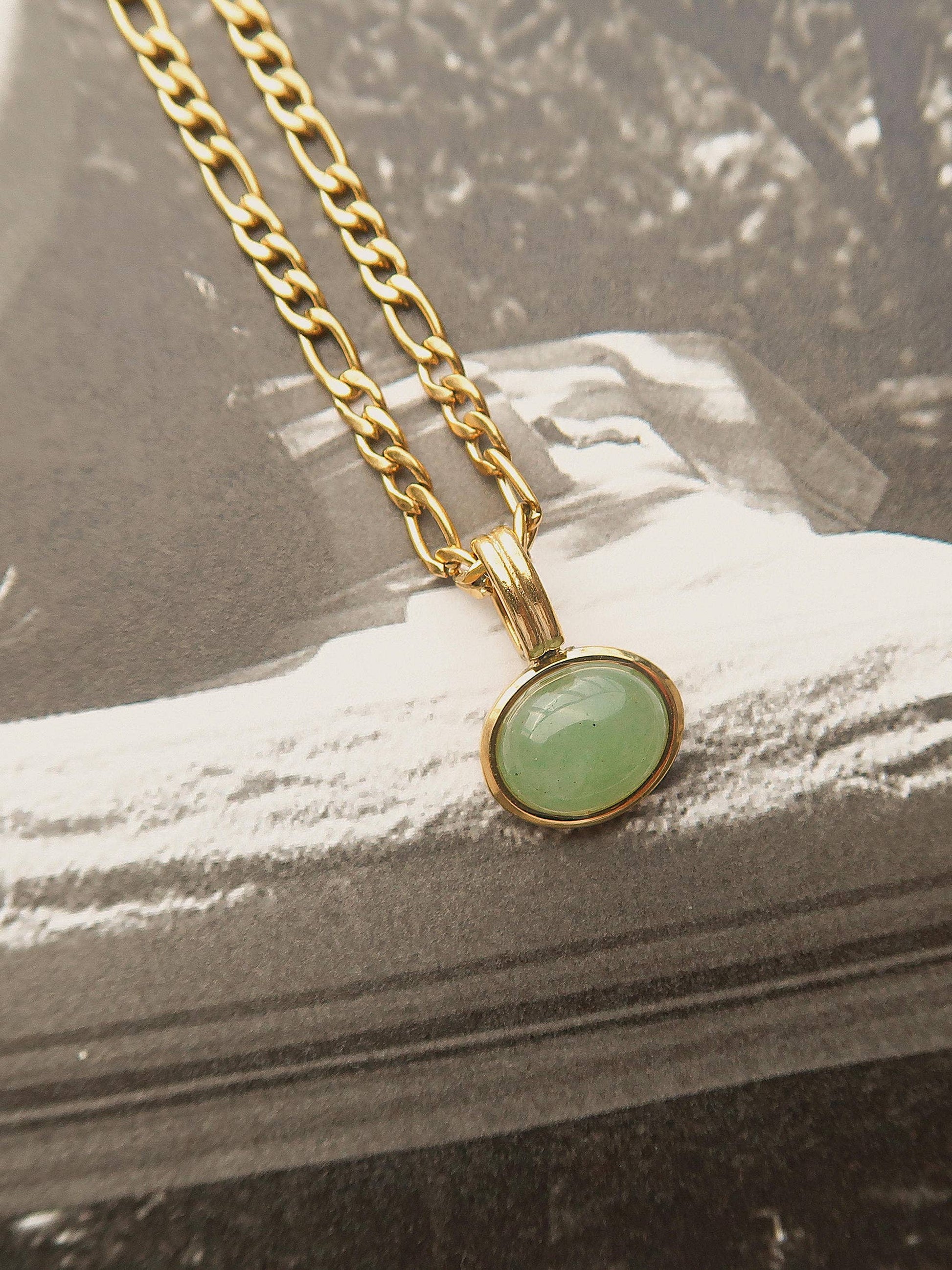 Necklace with a green pendant on a textured surface