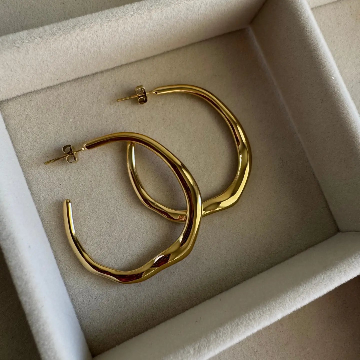 Gold hoop earrings in a jewelry box