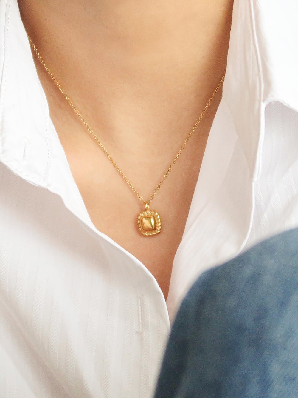 Classic petite square pendant on a models neck. 