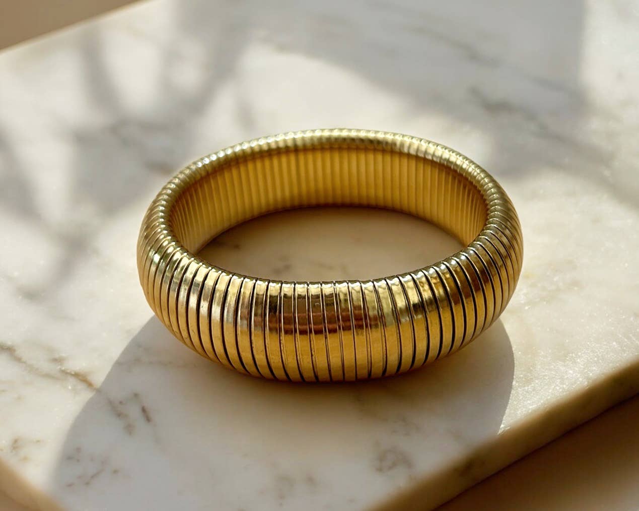 Gold bracelet on a marble surface